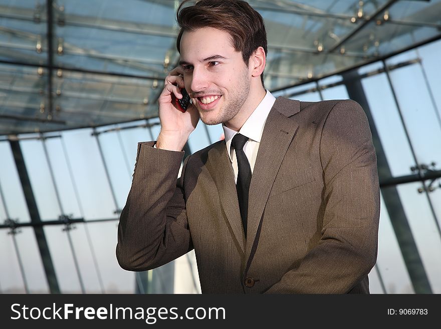 Man in suit stands with telephone. Man in suit stands with telephone