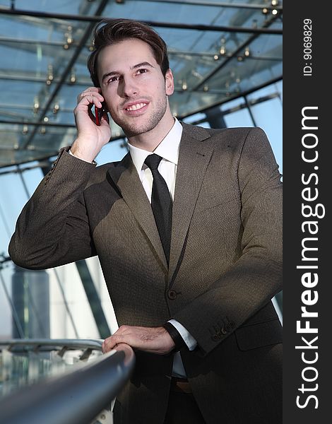 Man in suit stands with telephone. Man in suit stands with telephone
