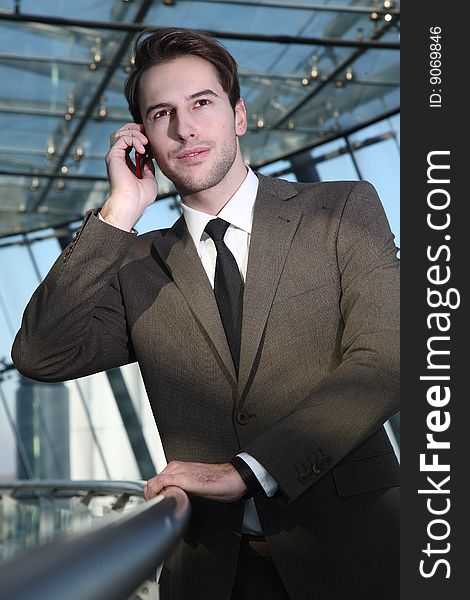 Man in suit stands with telephon. Man in suit stands with telephon