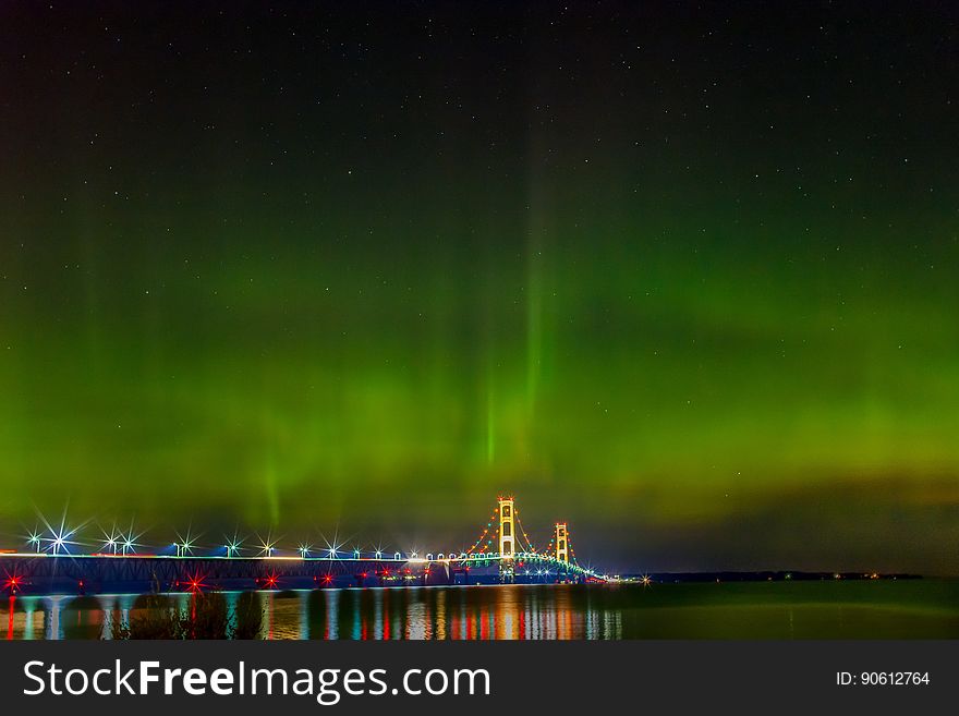 Aurora on the sky over a bridge with lights. Aurora on the sky over a bridge with lights.