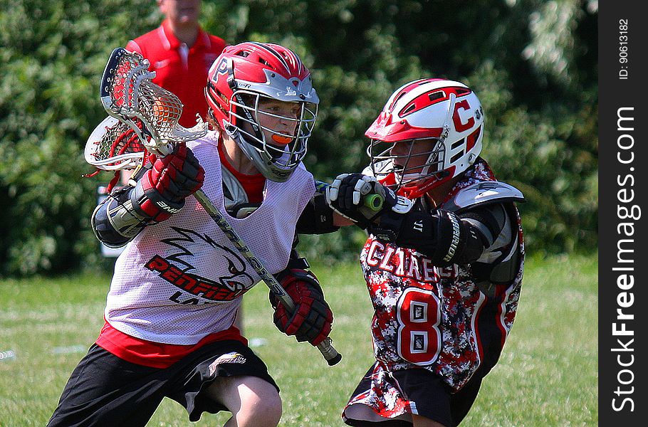 A pair of lacrosse players facing off during a game. A pair of lacrosse players facing off during a game.