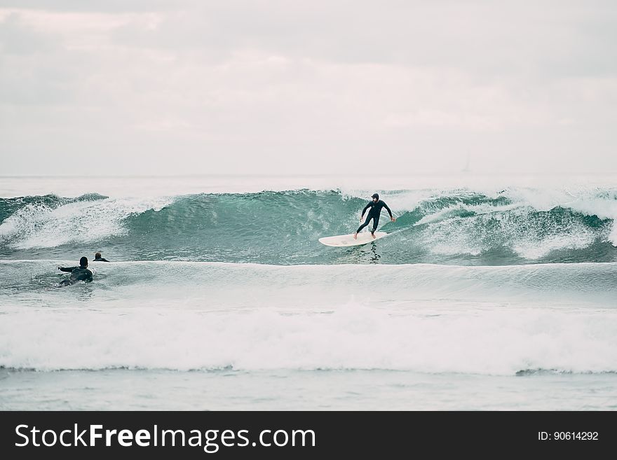 Surfers on boards riding waves at beach. Surfers on boards riding waves at beach.