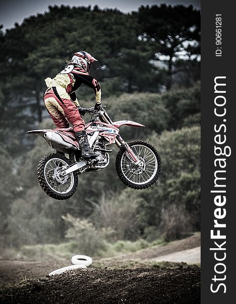 Motocross biker in safety uniform in air on dirt course. Motocross biker in safety uniform in air on dirt course.