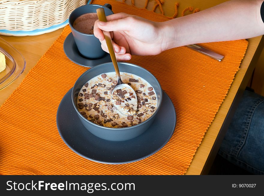 A young person is taking his muesli with chocolate