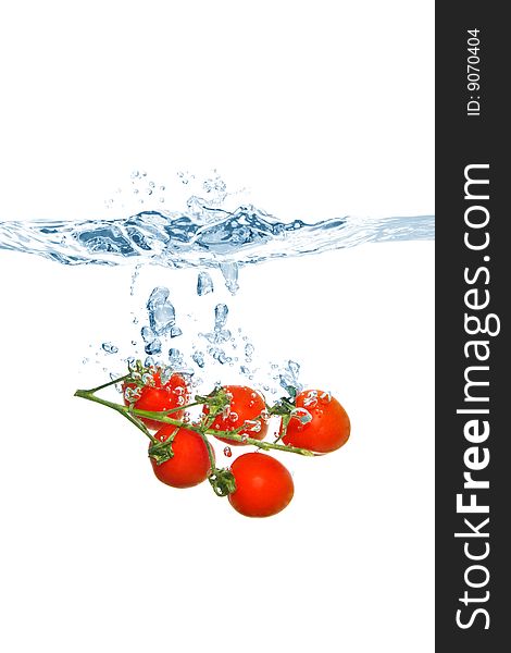 Cherry tomatoes falling into the water, isolated