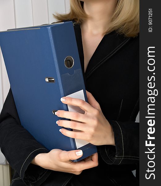 Folder for papers in hands at business of the woman in black clothes