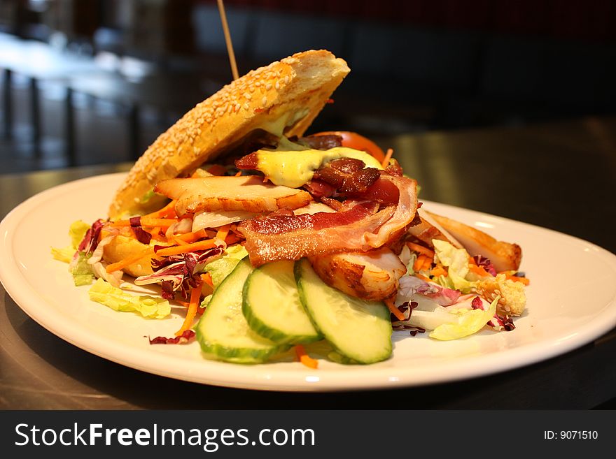 Club sandwich on white plate. With Bacon, chicken and salad.