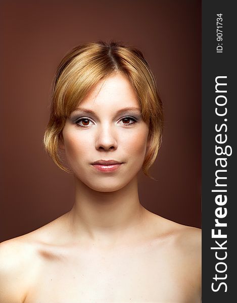 Beauty portrait of a young woman on brown background. Beauty portrait of a young woman on brown background