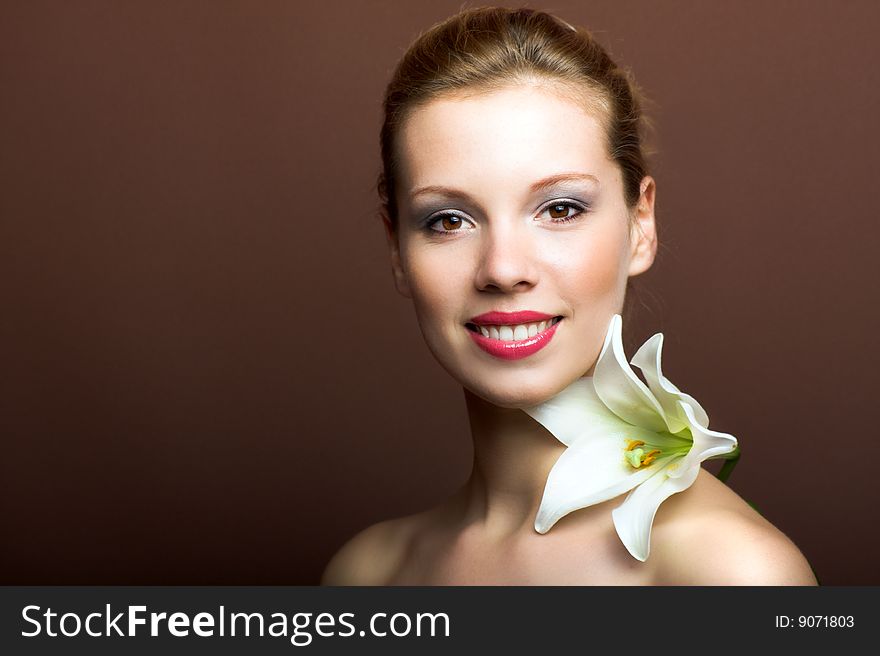 Beauty portrait of a young woman with a lily flower. Beauty portrait of a young woman with a lily flower