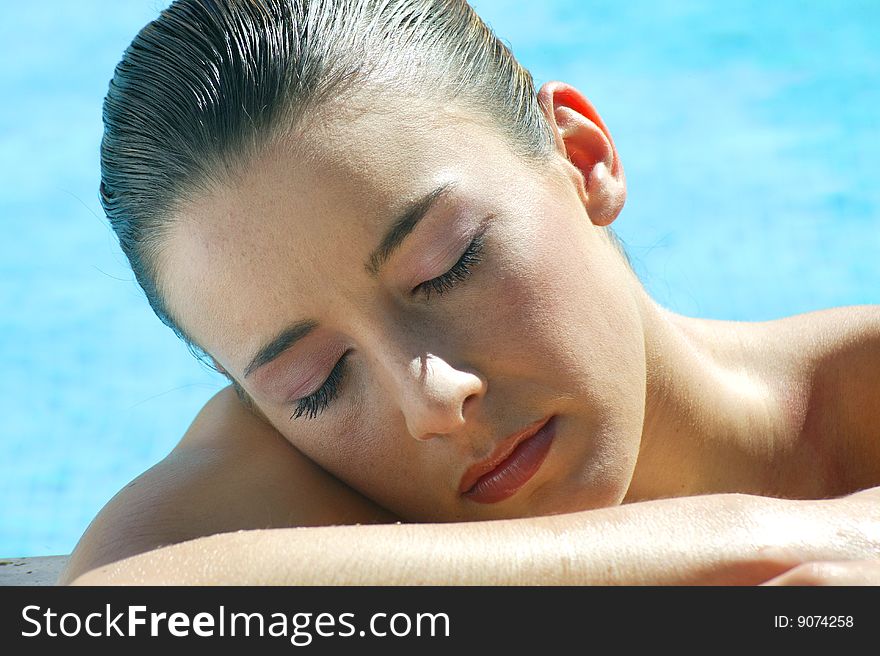 Young woman resting by the swimming pool, close-up. Young woman resting by the swimming pool, close-up