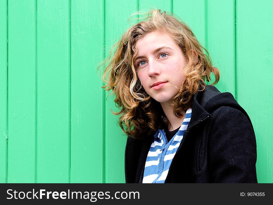 Pretty teenage girl against green wall