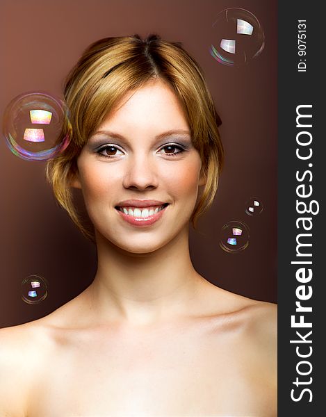 Beauty portrait of a young smiling woman with soap bubbles. Beauty portrait of a young smiling woman with soap bubbles