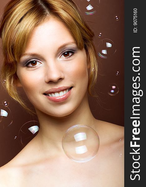 Beauty portrait of a young smiling woman with soap bubbles. Beauty portrait of a young smiling woman with soap bubbles