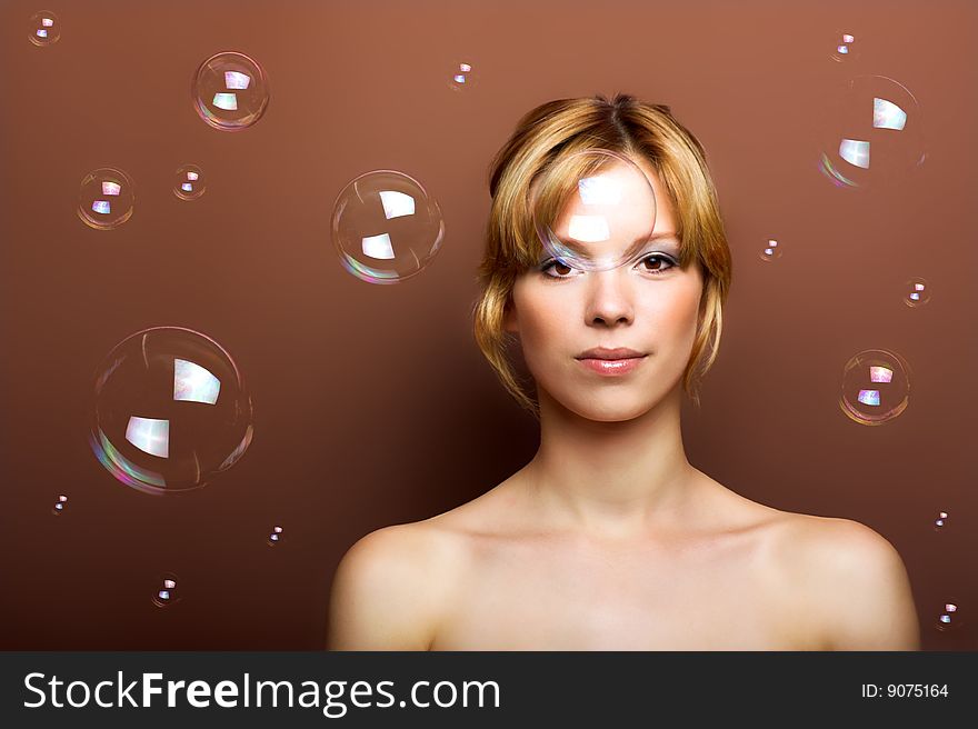 Beauty portrait of a young woman with soap bubbles