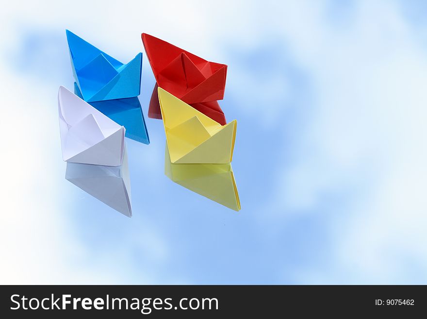 Colorful paper boats isolated on background with blue sky. Colorful paper boats isolated on background with blue sky