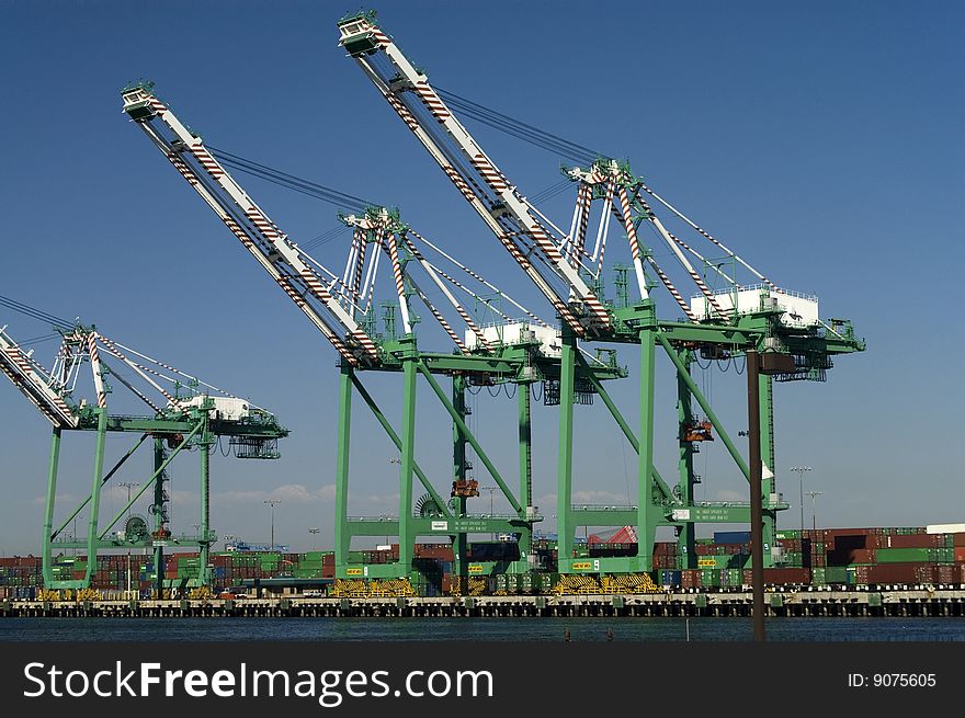 Large, modern cargo cranes are used to load container ships arriving at the port. Large, modern cargo cranes are used to load container ships arriving at the port.