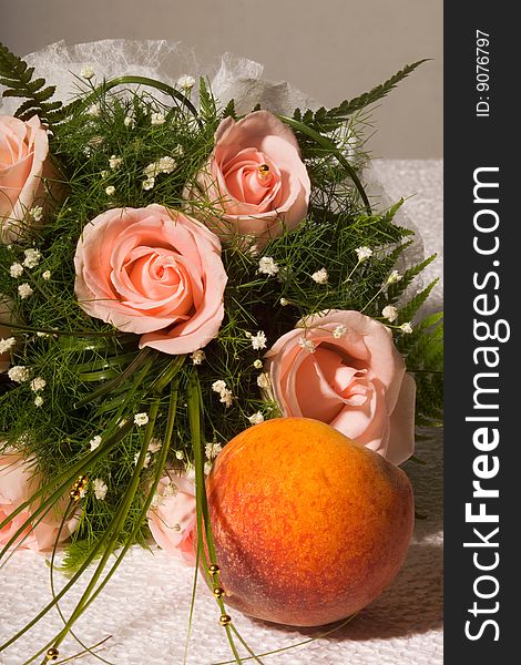 Bouquet of roses and peach on a table. Bouquet of roses and peach on a table