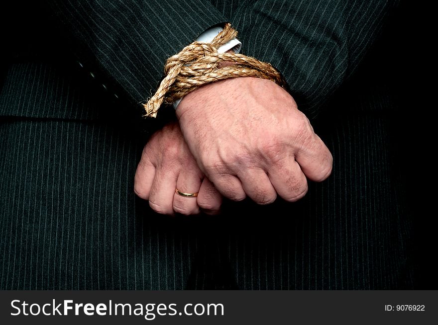 A horizontal view of a business man with his hands tied infront of him. Concept:My hands are tied