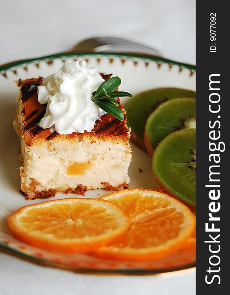 Cheesecake with whipped cream, tangerines and kiwi decoration. Cheesecake with whipped cream, tangerines and kiwi decoration.