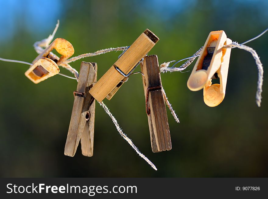 Old clothespins hang in the street on a cord. Old clothespins hang in the street on a cord.