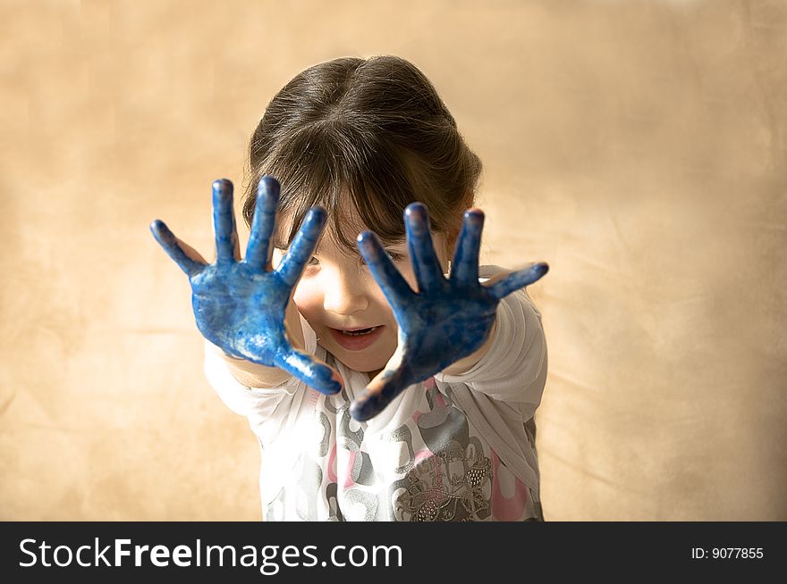 Girl with hands painted in blue paints ready for hand prints. Girl with hands painted in blue paints ready for hand prints.