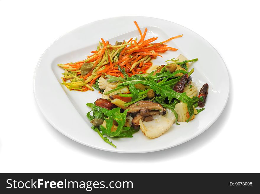 Octopus with mushrooms, orange carrot and green seaweed on the white plate. Octopus with mushrooms, orange carrot and green seaweed on the white plate