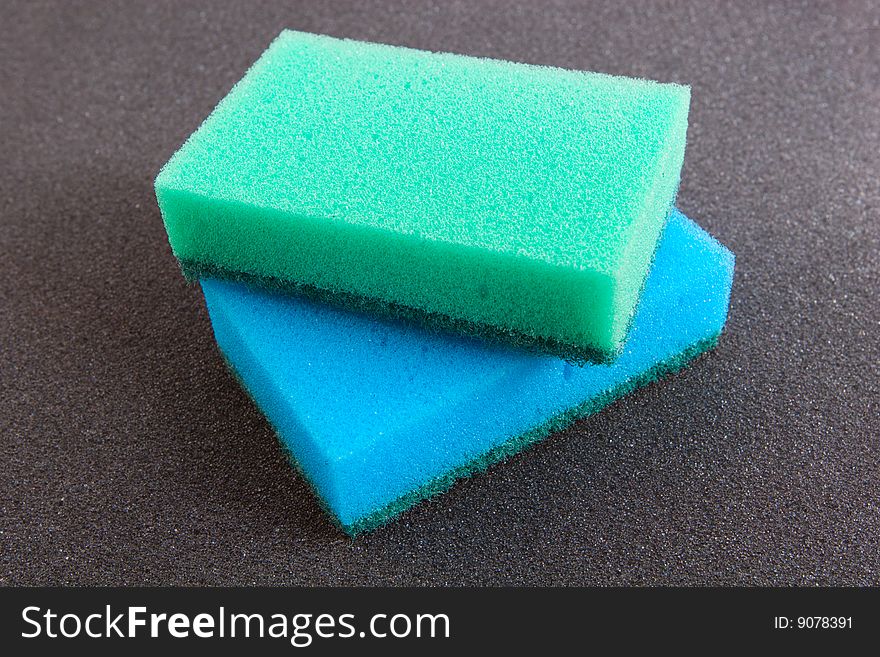 Cleaning tools: blue and green cleaning sponges isolated on grey