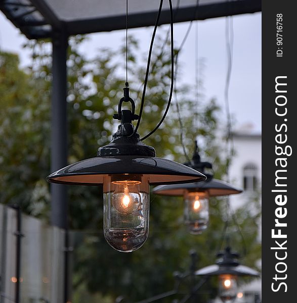 Clear glass bulbs in metal lamps illuminated in outdoors. Clear glass bulbs in metal lamps illuminated in outdoors.