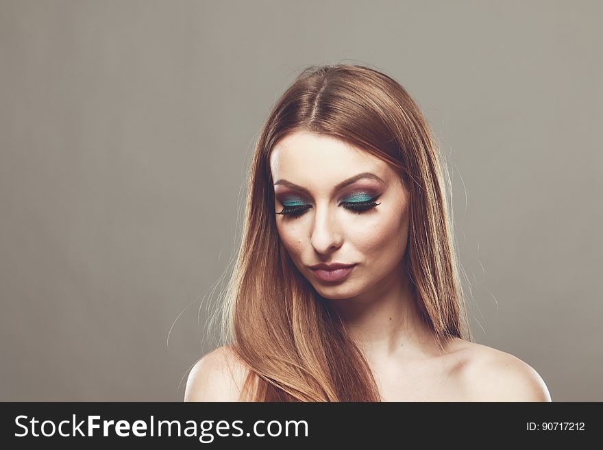 Indoor studio portrait of woman with long hair and bare chest.