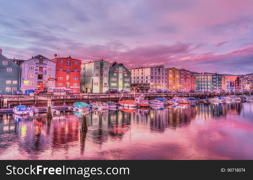 Coastal city reflecting in waterfront with boats at sunrise. Coastal city reflecting in waterfront with boats at sunrise.