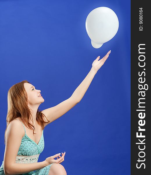 Pretty woman playing with white balloon
