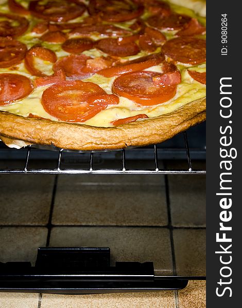 A tomato and cheese quiche being taken out of the oven. A tomato and cheese quiche being taken out of the oven.