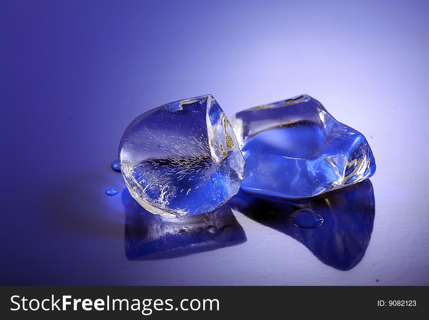 A image of Blue toned ice cubes on blue surface.