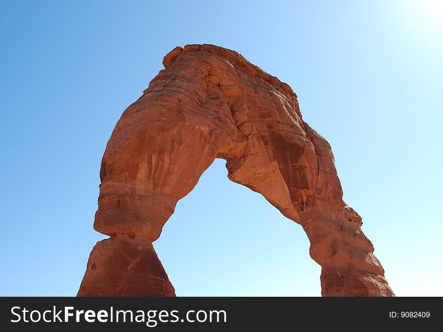 A picture of Delicate Arch in Arches National Park in the bright sun.