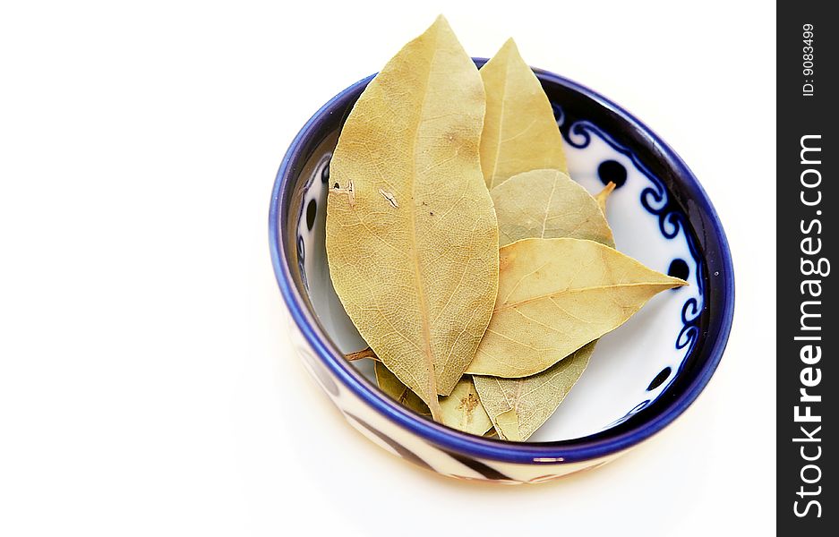 Bowl of bay leaves on a white background