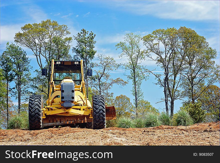 Yellow construction machinery against blue sky.