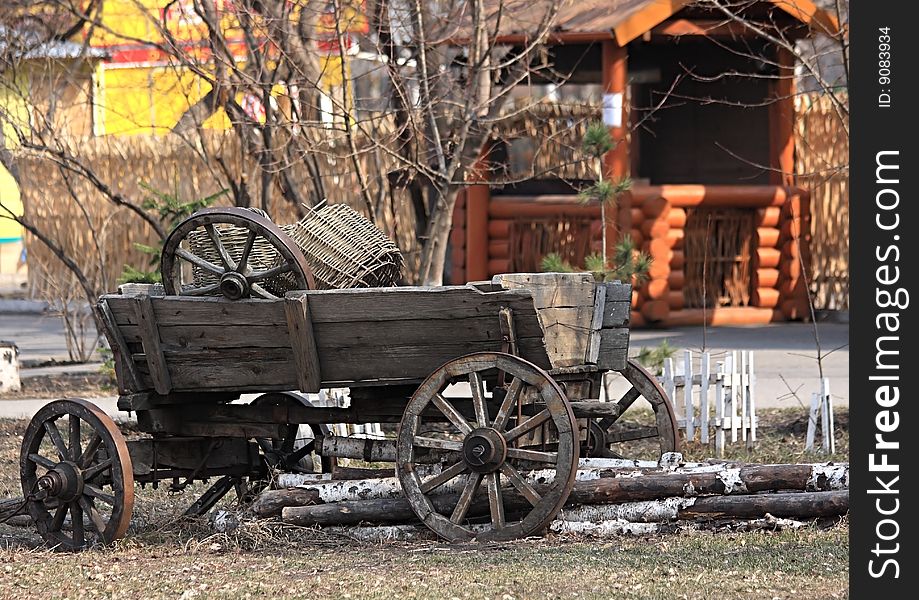 Age-old Russian cart with an utensil. Birch logs.