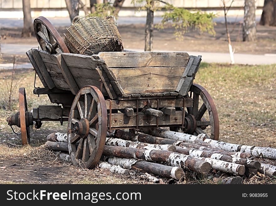 Age-old Russian cart with an utensil. Birch logs.