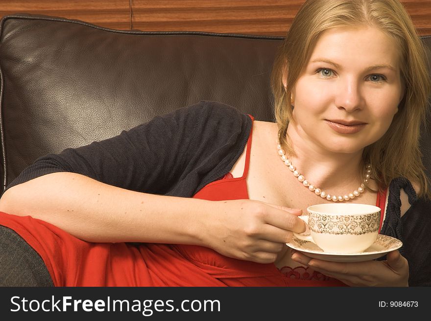 Beautiful young woman enjoying a cup of tea. Beautiful young woman enjoying a cup of tea