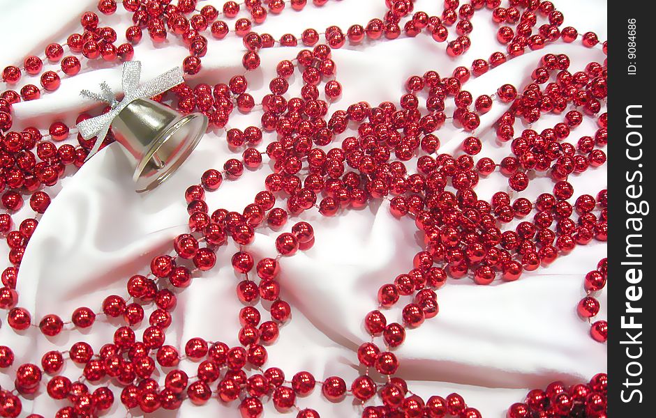 Red pearls lieing on white silk.