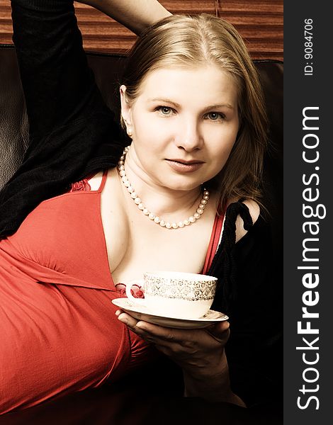 Beautiful young woman enjoying a cup of tea. Beautiful young woman enjoying a cup of tea