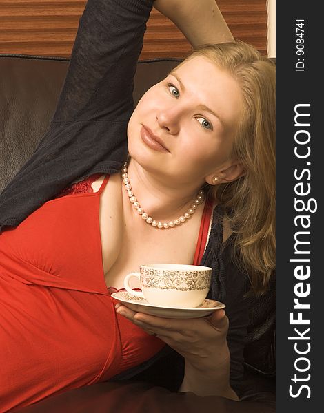 Beautiful young woman enjoying a cup of tea. Beautiful young woman enjoying a cup of tea