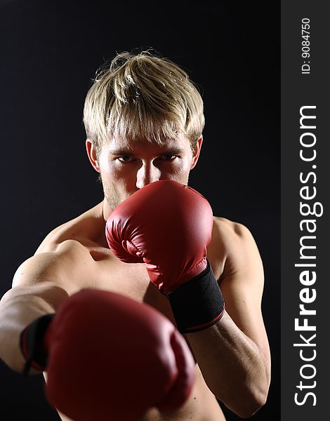 Young man stands with boxing gloves. Young man stands with boxing gloves