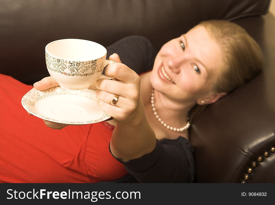 Beautiful young woman enjoying a cup of tea. Beautiful young woman enjoying a cup of tea