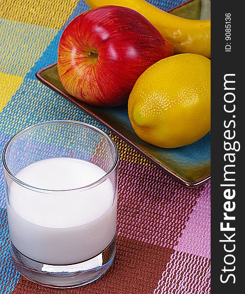 A bunch of fruits and a glass of milk. A bunch of fruits and a glass of milk