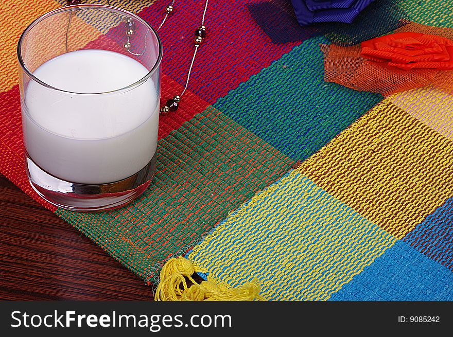 A glass of milk on a nice blanket. A glass of milk on a nice blanket