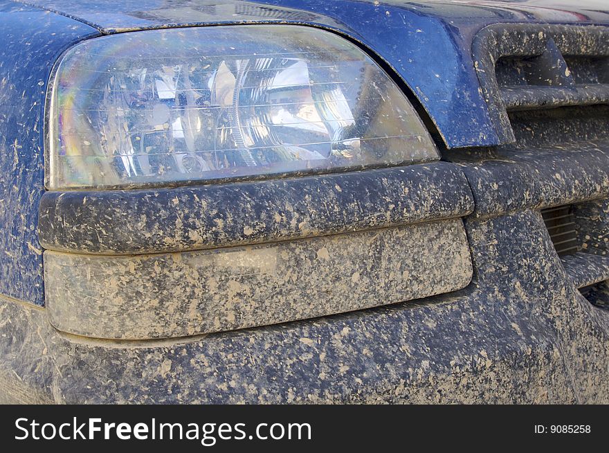 Mud on the front of a blue car