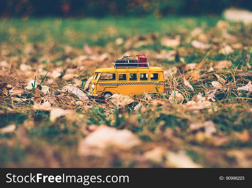 A toy minibus on green grass with fallen leaves. A toy minibus on green grass with fallen leaves.