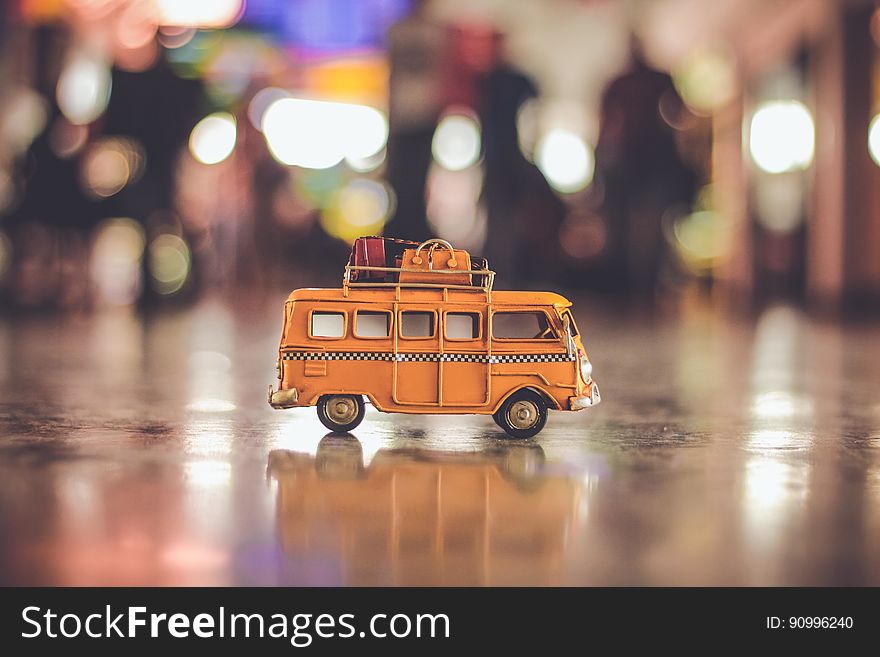 A toy minibus with luggage on the roof on a street. A toy minibus with luggage on the roof on a street.