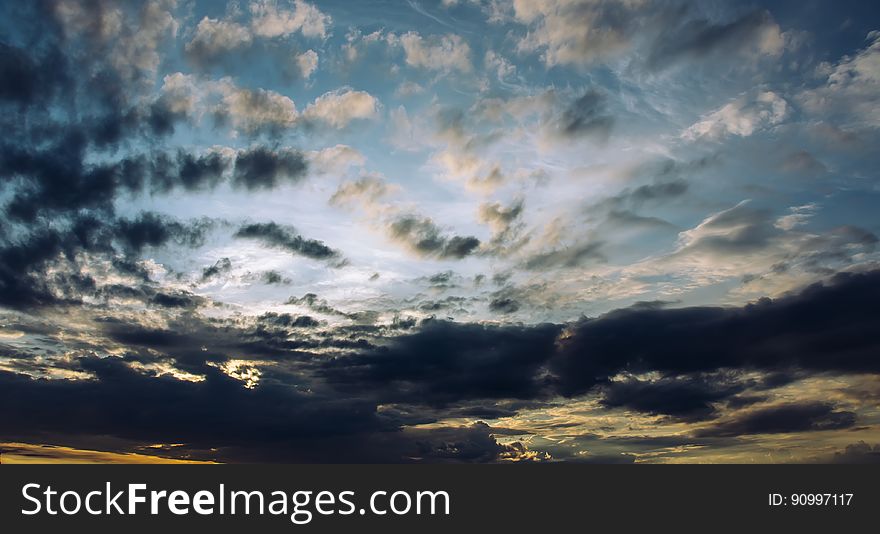 A blue sky with white clouds at sunset. A blue sky with white clouds at sunset.